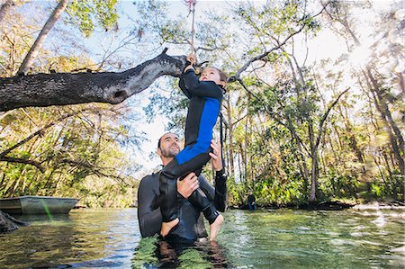 Father in river helping daughter with rope swing on tree, Chassahowitzka, Florida, USA Stock Photo - Premium Royalty-Free, Code: 614-08884772