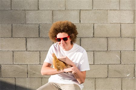 simsearch:614-08884812,k - Portrait of teenage boy with red afro hair, holding chicken Photographie de stock - Premium Libres de Droits, Code: 614-08884811
