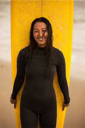 Portrait of young woman, holding surfboard Photographie de stock - Premium Libres de Droits, Code: 614-08884866