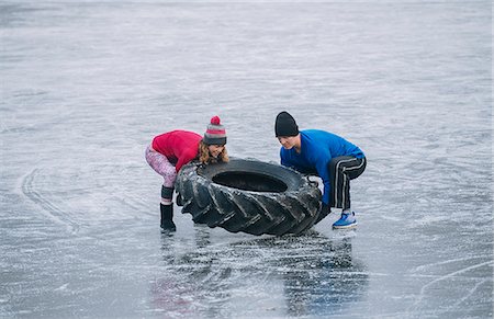 simsearch:614-08488024,k - Couple flipping tyre on frozen lake Photographie de stock - Premium Libres de Droits, Code: 614-08884958