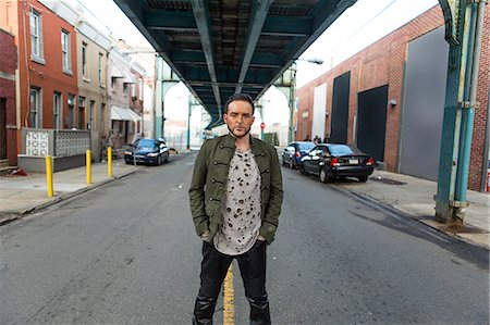 Portrait of mid adult man standing below elevated city road Stock Photo - Premium Royalty-Free, Code: 614-08885020