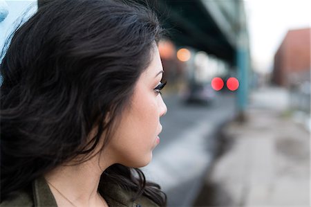 simsearch:614-08081431,k - Profile portrait of young woman in city looking over her shoulder Stock Photo - Premium Royalty-Free, Code: 614-08885021