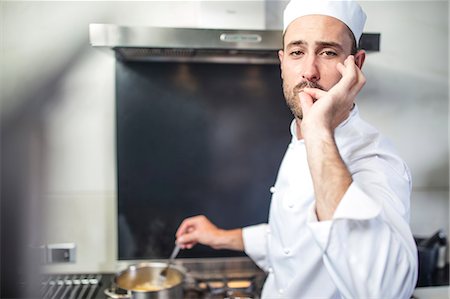 simsearch:614-08885076,k - Portrait of chef stirring pan on stove, signalling with fingers to lips Stock Photo - Premium Royalty-Free, Code: 614-08885079