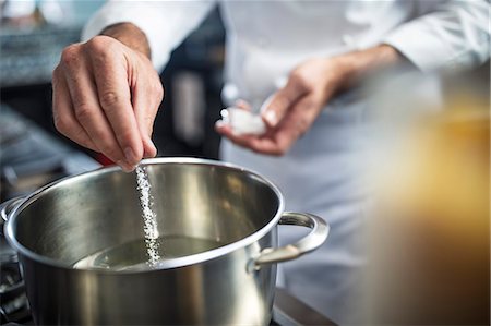 simsearch:614-08885076,k - Chef putting salt in pan of water on stove, close-up Stock Photo - Premium Royalty-Free, Code: 614-08885073