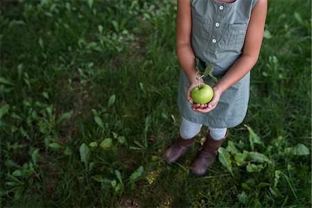 simsearch:614-08880760,k - Young girl holding fresh apple, low section Foto de stock - Royalty Free Premium, Número: 614-08880754