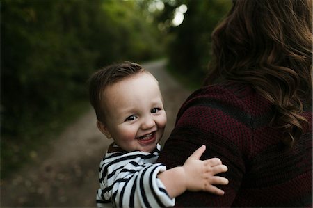 simsearch:6119-07845671,k - Baby boy in mother's arms looking at camera smiling Fotografie stock - Premium Royalty-Free, Codice: 614-08880818