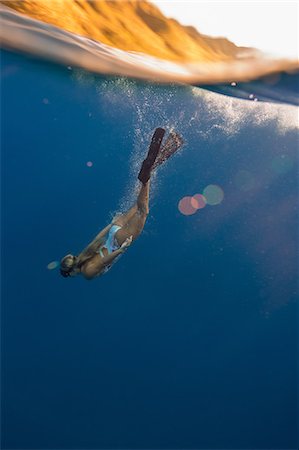 Woman wearing flippers swimming underwater, Oahu, Hawaii, USA Stock Photo - Premium Royalty-Free, Code: 614-08880829