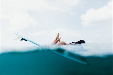 en dessous - Surface level view of woman lying on surfboard, Oahu, Hawaii, USA Photographie de stock - Premium Libres de Droits, Code: 614-08880841