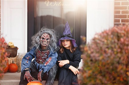 Friends dressed as witch and zombie, sitting on front step of home Stock Photo - Premium Royalty-Free, Code: 614-08880870