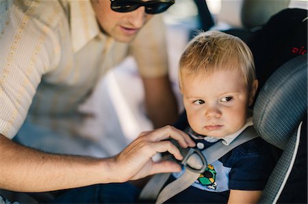 securing - Father securing young son in car seat Photographie de stock - Premium Libres de Droits, Code: 614-08880937