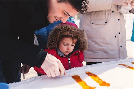 popsicle girl - Girl in fur hood with father making lolly in snow ice Stock Photo - Premium Royalty-Free, Code: 614-08880966