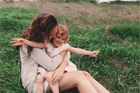 simsearch:862-08273030,k - Girl sitting on mother's lap on windy field Photographie de stock - Premium Libres de Droits, Code: 614-08880968