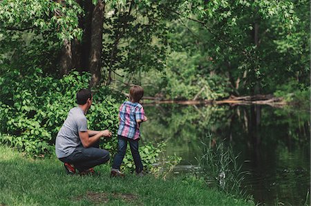 father son forest casual clothing two caucasian - Boy and father looking from forest riverbank Stock Photo - Premium Royalty-Free, Code: 614-08880960