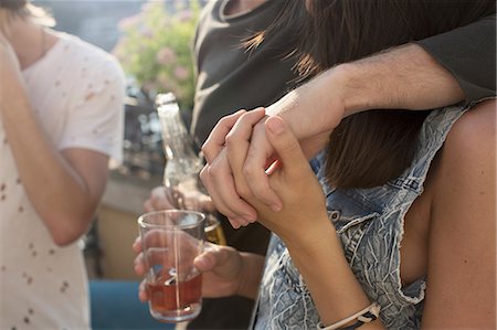 simsearch:614-08881018,k - Cropped shot of couple holding hands at roof terrace party Fotografie stock - Premium Royalty-Free, Codice: 614-08881017
