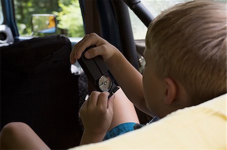 simsearch:614-08487786,k - Young boy in back of vehicle, looking at compass Stock Photo - Premium Royalty-Free, Code: 614-08881070