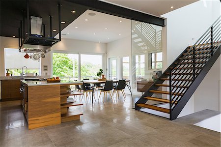 Kitchen, dining room and American walnut wood and black powder coated cold rolled steel stairs inside a modern cube style home, Quebec, Canada Stock Photo - Premium Royalty-Free, Code: 614-08881121