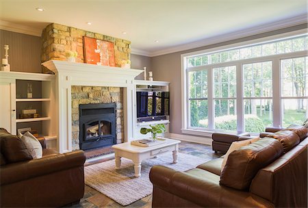 simsearch:614-08488004,k - Brown leather sofa, sitting chairs and natural stone fireplace in the living room inside a cottage style home, Quebec, Canada Foto de stock - Sin royalties Premium, Código: 614-08881134