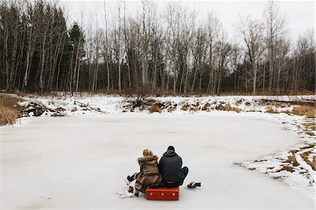 simsearch:649-09139103,k - Couple sitting on red suitcase in middle of frozen lake, Whitby, Ontario, Canada Photographie de stock - Premium Libres de Droits, Code: 614-08881139