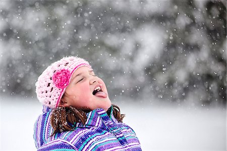 sticking out tongue in snow - Girl catching snowflake on her tongue Stock Photo - Premium Royalty-Free, Code: 614-08881236