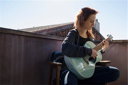 simsearch:614-00658816,k - Teenager playing guitar on roof terrace Photographie de stock - Premium Libres de Droits, Code: 614-08881246