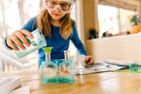 Girl doing science experiment, pouring liquid into flask Foto de stock - Royalty Free Premium, Número: 614-08881295