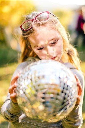Girl in sunlit garden gazing at disco ball Photographie de stock - Premium Libres de Droits, Code: 614-08881308