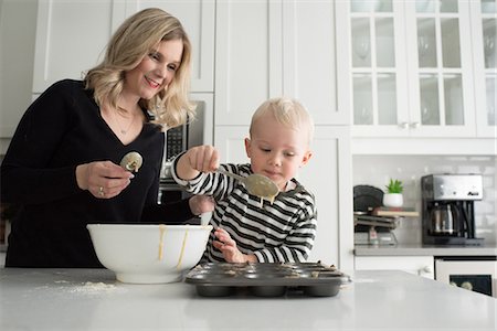 people in kitchen at home - Mother and son baking together, putting mixture into baking tray Stock Photo - Premium Royalty-Free, Code: 614-08881345