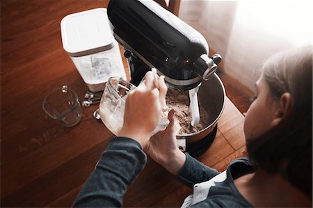 simsearch:649-07280354,k - Young girl pouring ingredients into bowl of food mixer, overhead view Fotografie stock - Premium Royalty-Free, Codice: 614-08881378