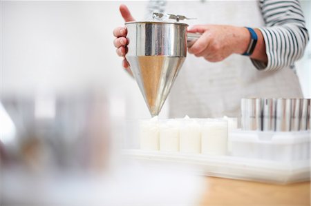 simsearch:614-08881367,k - Senior woman in kitchen, using pancake funnel to dispense cream, homemade cosmetics, into pots, mid section Photographie de stock - Premium Libres de Droits, Code: 614-08881372