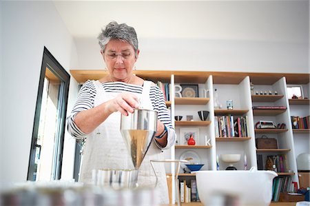 simsearch:614-08881367,k - Senior woman in kitchen, using pancake funnel to dispense cream, homemade cosmetics, into pots, mid section Photographie de stock - Premium Libres de Droits, Code: 614-08881373