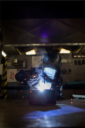 Female metalsmith welding metal box on workbench Stock Photo - Premium Royalty-Free, Code: 614-08881404