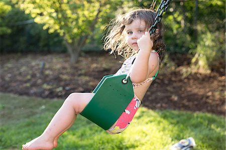 Girl swinging on garden swing Stock Photo - Premium Royalty-Free, Code: 614-08908367