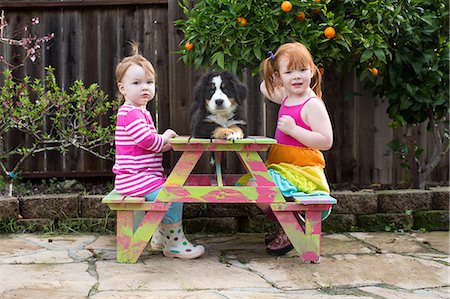 simsearch:614-08926023,k - Two young sisters sitting on garden bench with pet dog Stock Photo - Premium Royalty-Free, Code: 614-08908384