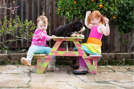 simsearch:614-08872572,k - Two young sisters sitting on garden bench with pet dog Photographie de stock - Premium Libres de Droits, Code: 614-08908385