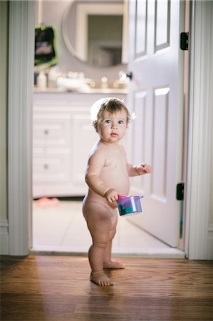 Portrait of naked female toddler standing in doorway Stock Photo - Premium Royalty-Free, Code: 614-08908397