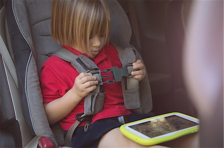 simsearch:632-05845591,k - Girl in car safety seat fastening her seat belt Stock Photo - Premium Royalty-Free, Code: 614-08908452