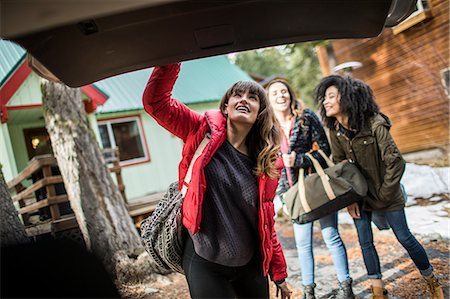 fermer - Friends standing outside cabin, young woman closing boot of car Photographie de stock - Premium Libres de Droits, Code: 614-08908579