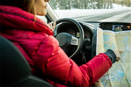 Woman driving car, pointing at map, mid section Stock Photo - Premium Royalty-Free, Code: 614-08908590