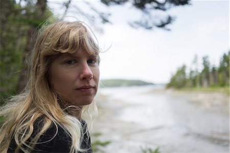 Portrait of woman looking over her shoulder at coast of Maine, USA Fotografie stock - Premium Royalty-Free, Codice: 614-08908615