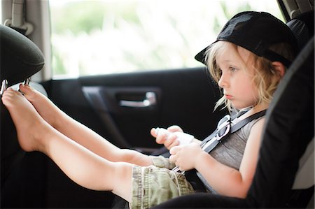 Male toddler with feet up staring in back seat of car Stock Photo - Premium Royalty-Free, Code: 614-08926058