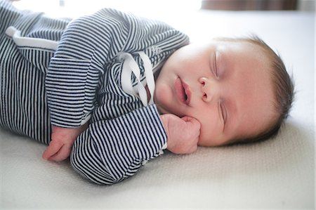 simsearch:614-08881045,k - Cute baby boy with hand on chin asleep on bed Fotografie stock - Premium Royalty-Free, Codice: 614-08926115