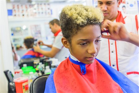 salon african american - Hairdresser cutting teenage boy's hair in barbershop Stock Photo - Premium Royalty-Free, Code: 614-08926200