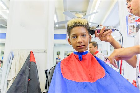 salon african american - Hairdresser cutting teenage boy's hair in barbershop Stock Photo - Premium Royalty-Free, Code: 614-08926201