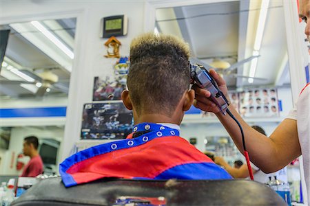 Hairdresser cutting teenage boy's hair in barbershop Foto de stock - Sin royalties Premium, Código: 614-08926203