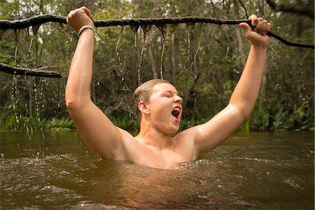 simsearch:614-08926342,k - Teenage boy in water holding tree branch jubilantly, Turkey Creek, Niceville, Florida, USA Stockbilder - Premium RF Lizenzfrei, Bildnummer: 614-08926348