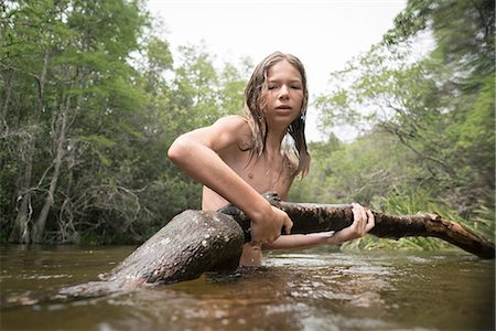 photo boy swimming - Teenage boy in lake holding tree branch Photographie de stock - Premium Libres de Droits, Code: 614-08926342