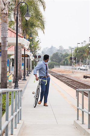 simsearch:614-08926457,k - Young businessman cyclist looking back from rail station platform Foto de stock - Sin royalties Premium, Código: 614-08926455