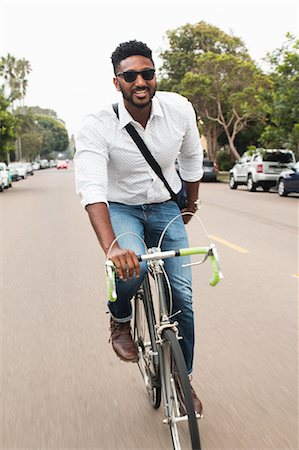 simsearch:614-08926457,k - Happy young man cycling along road Foto de stock - Sin royalties Premium, Código: 614-08926450