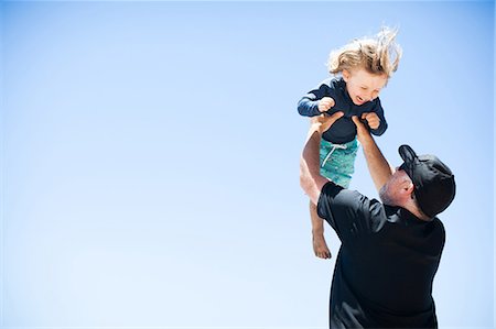 Father and son fooling around outdoors, father lifting son in air Stock Photo - Premium Royalty-Free, Code: 614-08926588