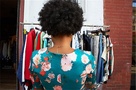 simsearch:851-02963162,k - Rear view of young female fashion blogger with afro hair looking at vintage clothes rail, New York, USA Foto de stock - Sin royalties Premium, Código: 614-08926692